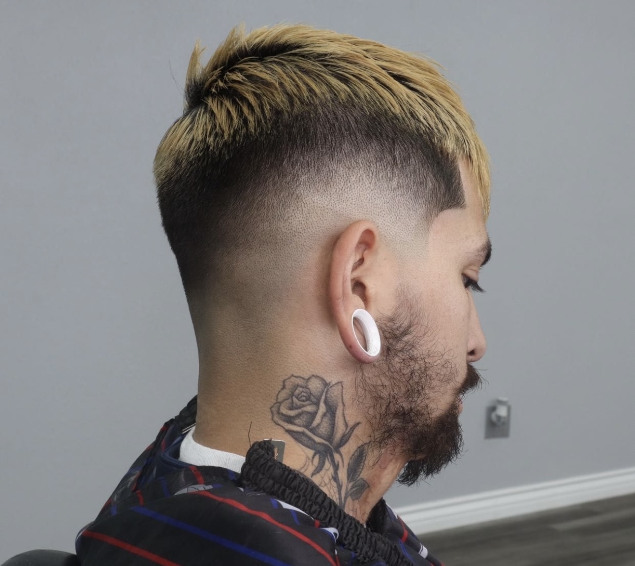 Man with blonde textured top, burst fade and neck rose tattoo, rear side view